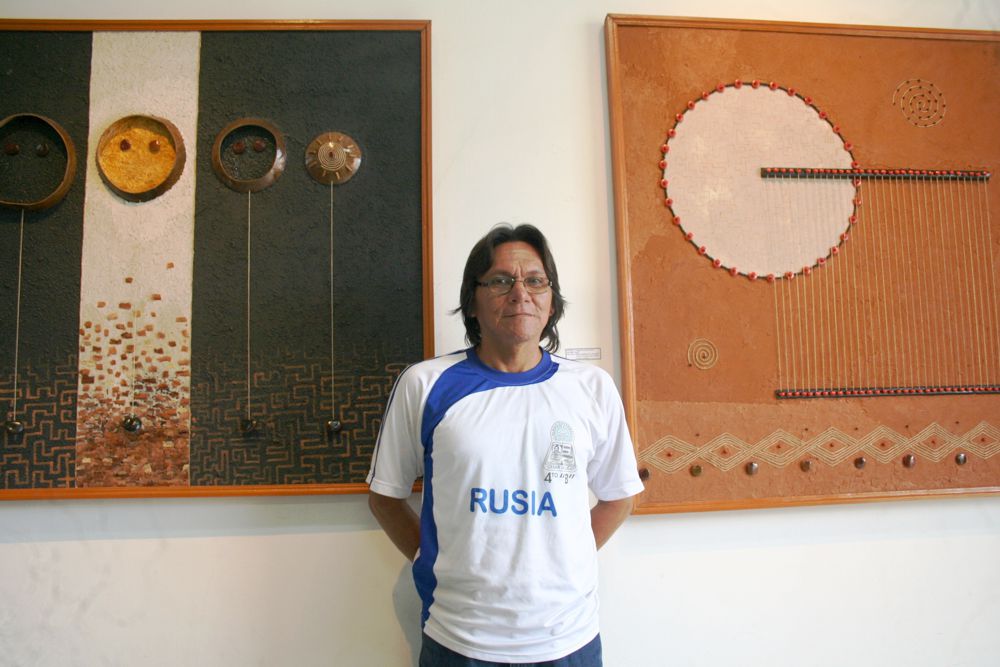 Aquí, Emilio, posando junto a los cuadros de Jorge Romero más conocido como "Llorll", joven que innova el arte