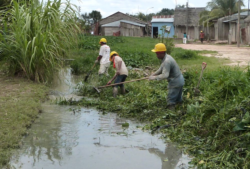 Obreros de la empresa china despejando el caño para que fluyan las aguas servidas, luego que desagüe fue cerrado por trabajos en la zona.