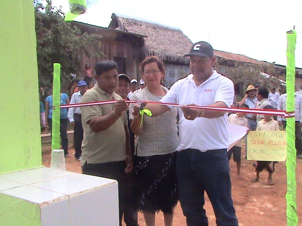 Alcalde Darwin Grández inaugurando piletas de agua junto a regidora Ester Salas y morador.