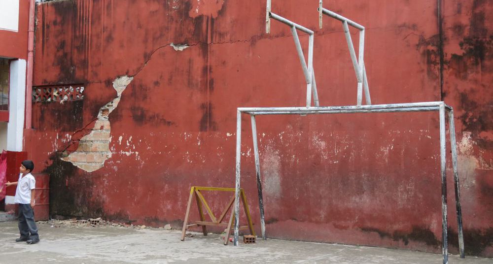 Se puede apreciar la pared totalmente erosionada y que la cancha múltiple no cuenta con aros ni tablero de básquet